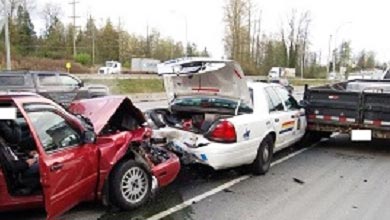 La voiture rouge endommagée a embouti l’arrière d’une auto-patrouille de la GRC, en bordure de route. 